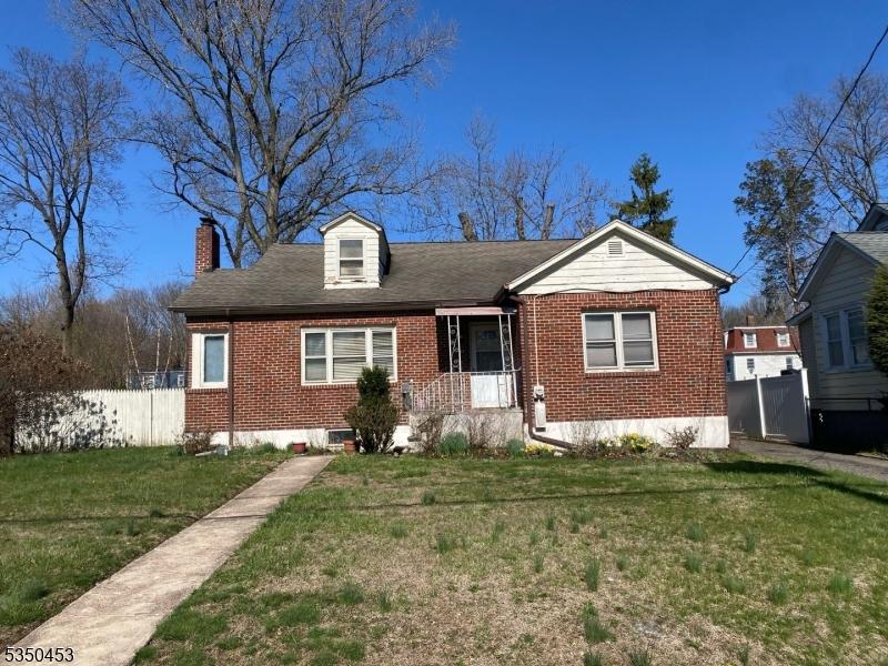 142 Orange St, Englewood City, NJ 07631 - view of front of property featuring fence, a chimney, brick siding, and a front yard