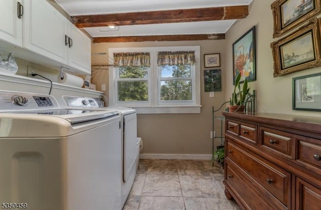 laundry area featuring washing machine and clothes dryer, baseboards, and cabinet space