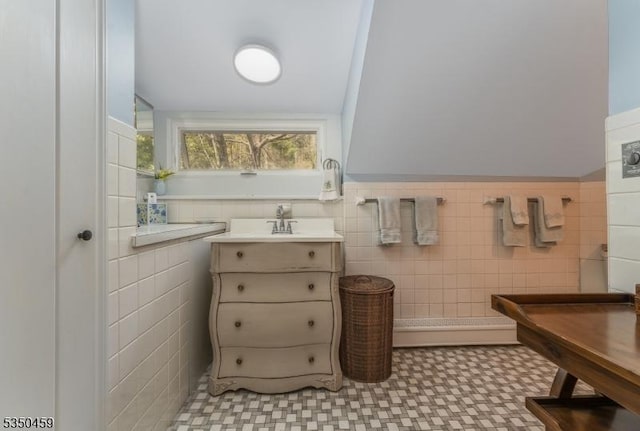 bathroom featuring a sink, wainscoting, tile patterned floors, and tile walls