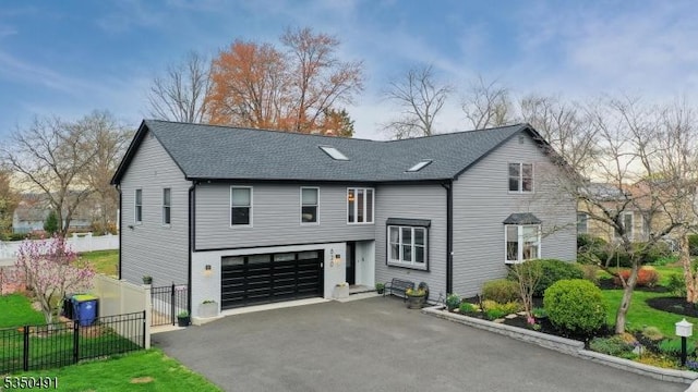 view of front of house featuring an attached garage, fence, roof with shingles, and aphalt driveway