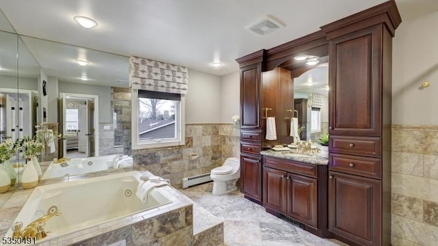 full bathroom featuring a baseboard heating unit, tile walls, toilet, and a jetted tub
