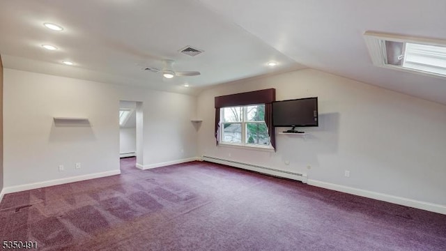 interior space with a baseboard heating unit, dark carpet, vaulted ceiling, and visible vents