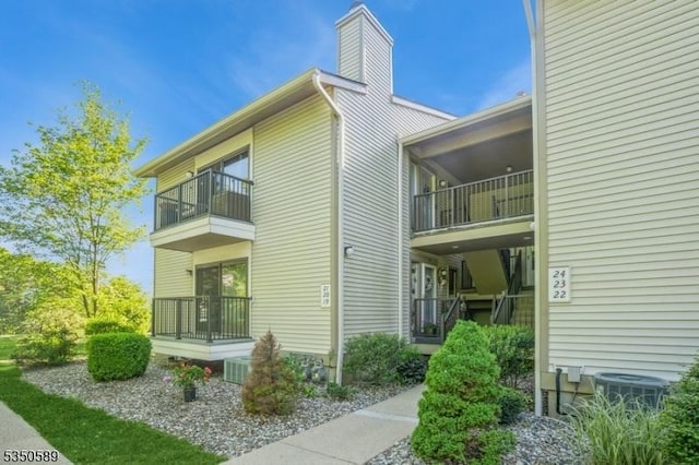 view of side of home featuring a balcony and a chimney