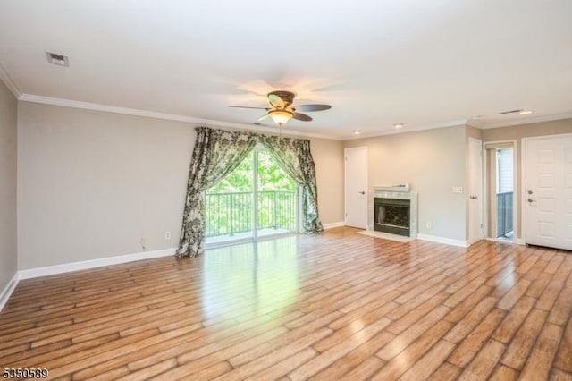 unfurnished living room featuring a ceiling fan, baseboards, ornamental molding, wood finished floors, and a fireplace with flush hearth