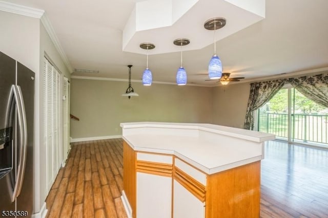 kitchen with stainless steel refrigerator with ice dispenser, crown molding, wood finished floors, ceiling fan, and light countertops