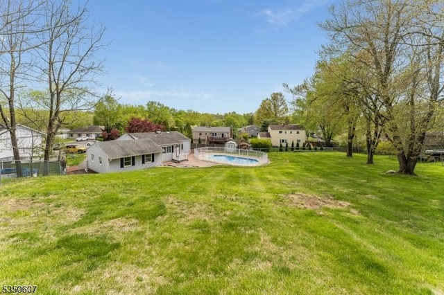 view of yard featuring an outdoor pool and fence