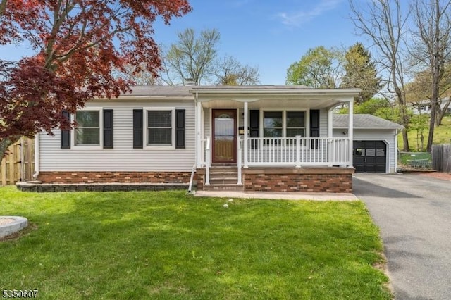 ranch-style home with a porch, driveway, a garage, fence, and a front lawn