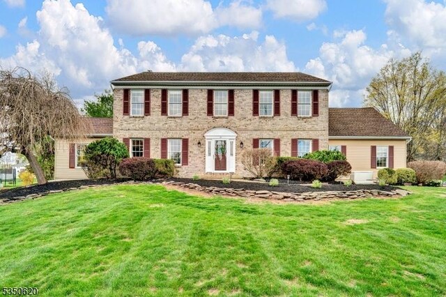 colonial inspired home featuring a front yard