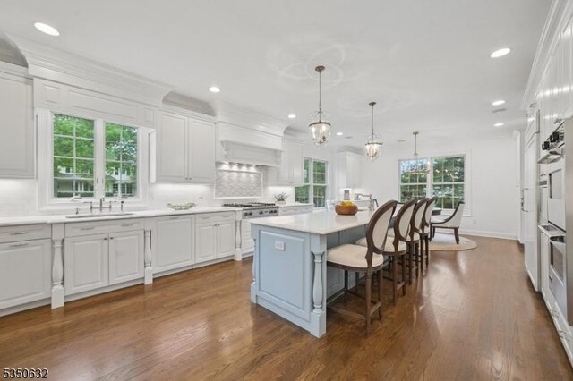 260 Hartshorn Dr, Millburn Twp, NJ 07078 - kitchen with a sink, white cabinetry, a breakfast bar, recessed lighting, and a kitchen island