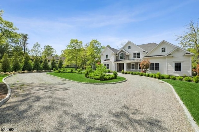 260 Hartshorn Dr, Millburn Twp, NJ 07078 - view of front of property featuring curved driveway, a standing seam roof, a front lawn, and metal roof