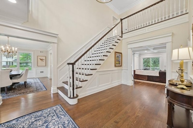 260 Hartshorn Dr, Millburn Twp, NJ 07078 - foyer entrance with stairs, a chandelier, a decorative wall, dark wood finished floors, and crown molding