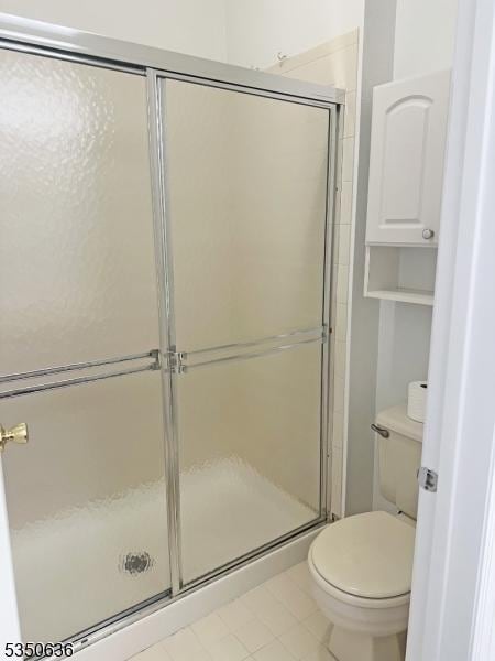 full bathroom featuring toilet, a shower stall, and tile patterned flooring