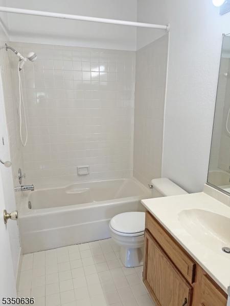 bathroom featuring tile patterned flooring, shower / washtub combination, toilet, and vanity