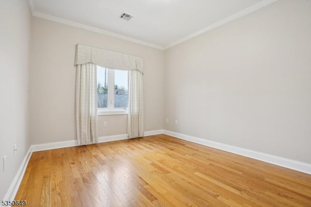 unfurnished room with crown molding, visible vents, baseboards, and light wood-style floors