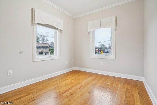 unfurnished room featuring baseboards, light wood-type flooring, and ornamental molding
