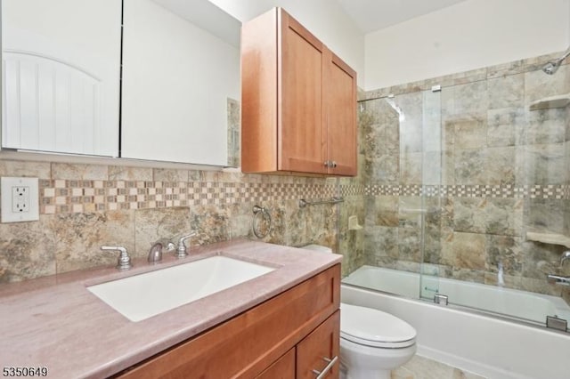 full bath with toilet, vanity, decorative backsplash, and shower / bath combination with glass door
