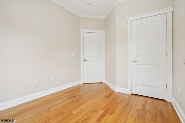 unfurnished bedroom with ornamental molding, baseboards, and light wood-type flooring