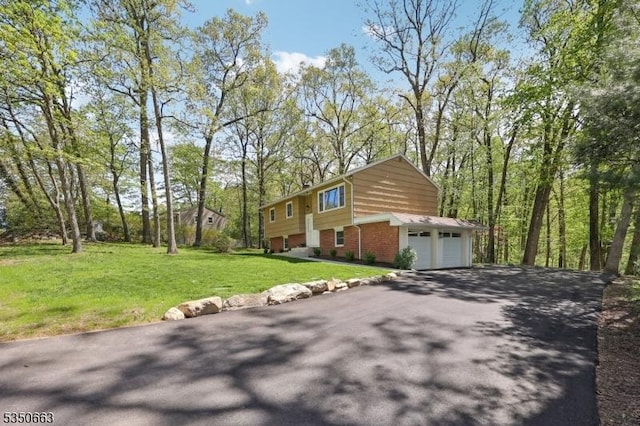 view of property exterior featuring a yard, brick siding, driveway, and a garage
