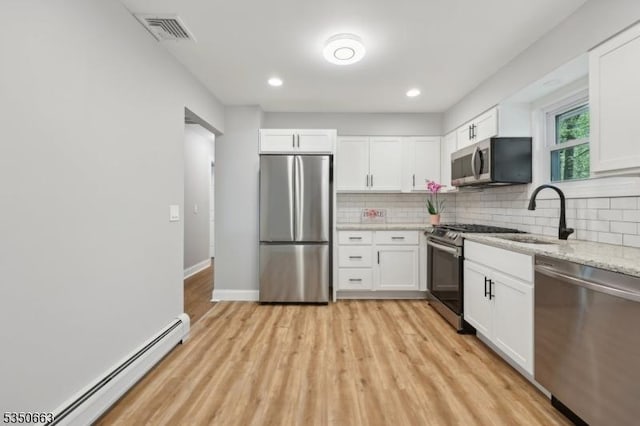 kitchen featuring backsplash, appliances with stainless steel finishes, visible vents, and a baseboard radiator