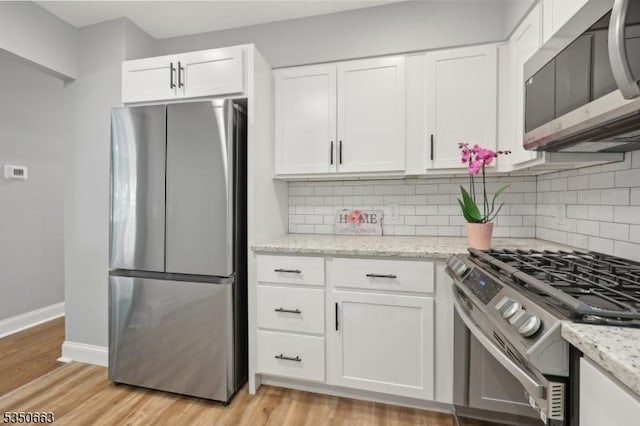 kitchen featuring decorative backsplash, stainless steel appliances, and white cabinetry