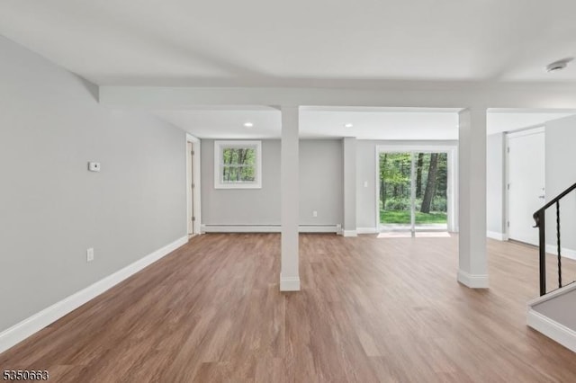 basement with baseboards, plenty of natural light, and light wood-style flooring