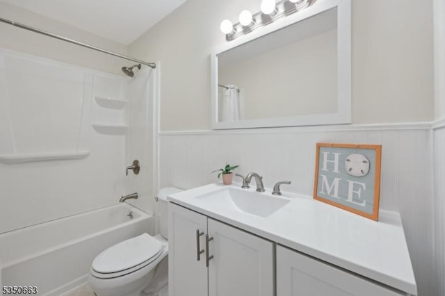 bathroom with toilet, wainscoting, shower / tub combo, and vanity
