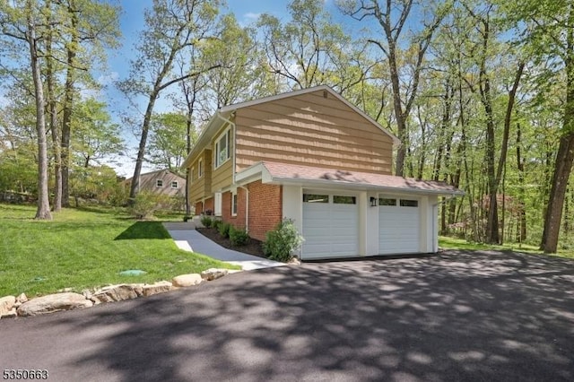 view of home's exterior with a lawn, brick siding, aphalt driveway, and a garage