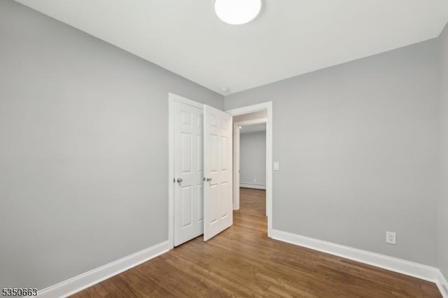 unfurnished bedroom with baseboards and wood finished floors