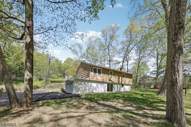 back of house with a yard and a chimney