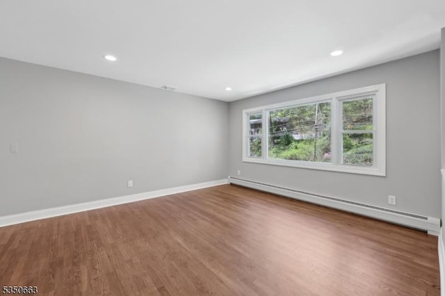 unfurnished room featuring baseboards, recessed lighting, wood finished floors, and baseboard heating