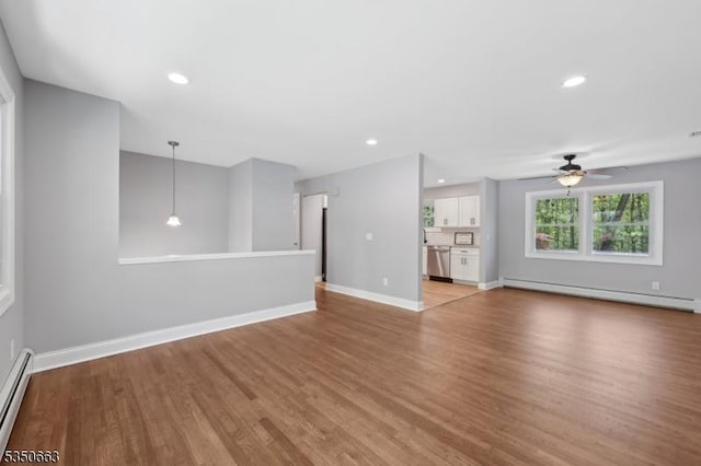 unfurnished living room featuring baseboards, a baseboard radiator, light wood-style flooring, and ceiling fan
