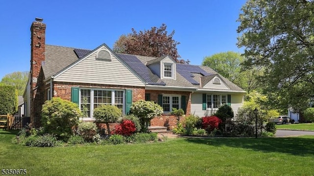 new england style home featuring a chimney and a front lawn