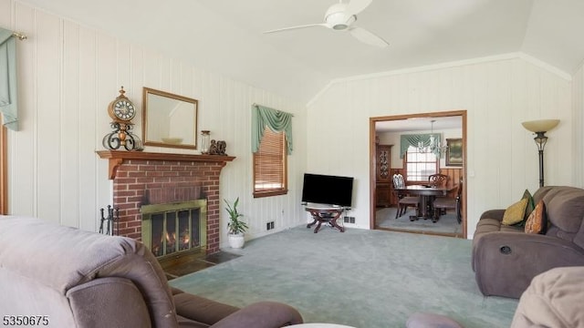 living room with carpet, a brick fireplace, lofted ceiling, and ceiling fan