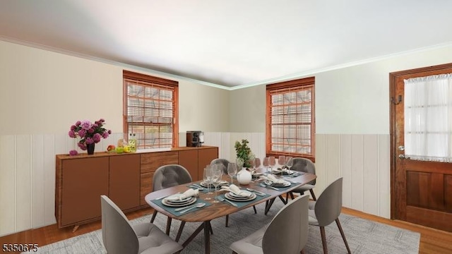 dining room featuring crown molding, a wainscoted wall, and wood finished floors