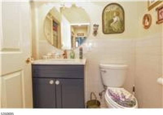 half bathroom with vanity, radiator, and toilet