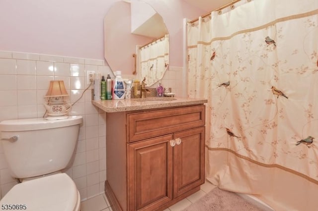 bathroom with vanity, tile patterned flooring, toilet, and tile walls