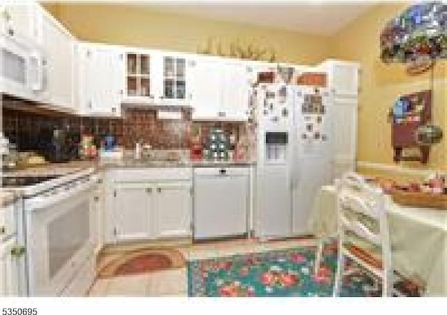 kitchen with white cabinetry, light countertops, and glass insert cabinets