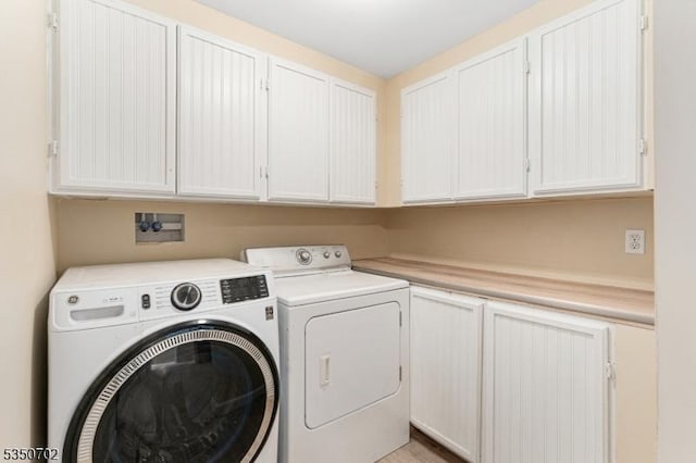 washroom featuring separate washer and dryer and cabinet space