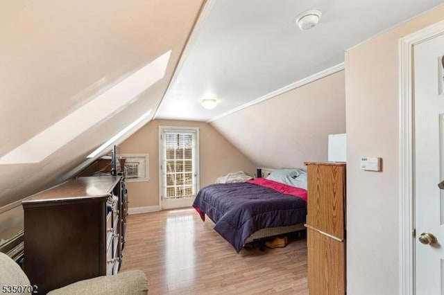 bedroom with light wood-style flooring, baseboards, and lofted ceiling