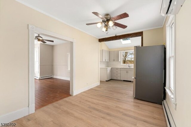 kitchen featuring baseboard heating, a wall mounted AC, freestanding refrigerator, and ceiling fan