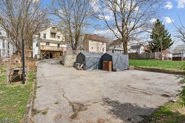 exterior space with fence, a residential view, and an outdoor structure
