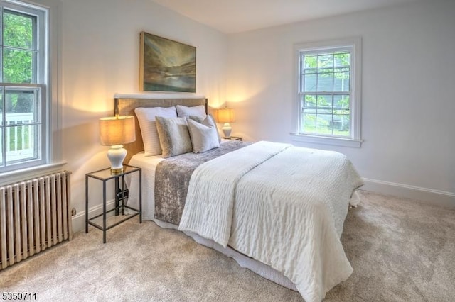 bedroom with radiator, carpet floors, and baseboards