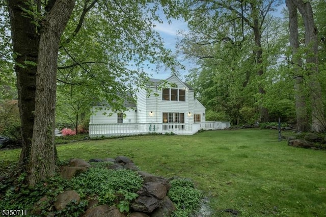 back of house with a lawn and a wooden deck