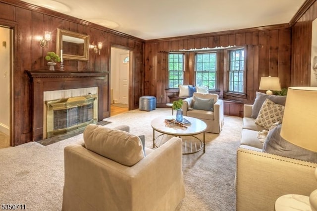 living room with a fireplace with flush hearth, light colored carpet, ornamental molding, wood walls, and baseboards
