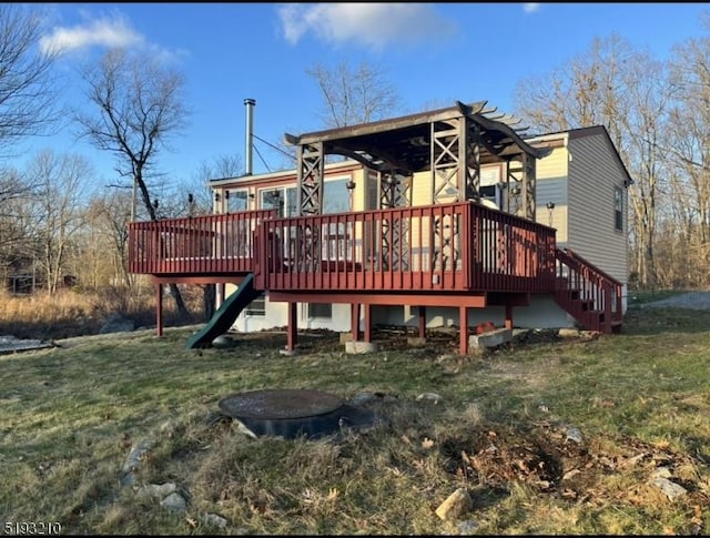 back of house with a wooden deck, a yard, and stairway