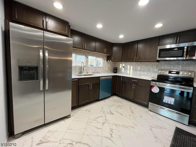 kitchen featuring dark brown cabinetry, stainless steel appliances, light countertops, and a sink