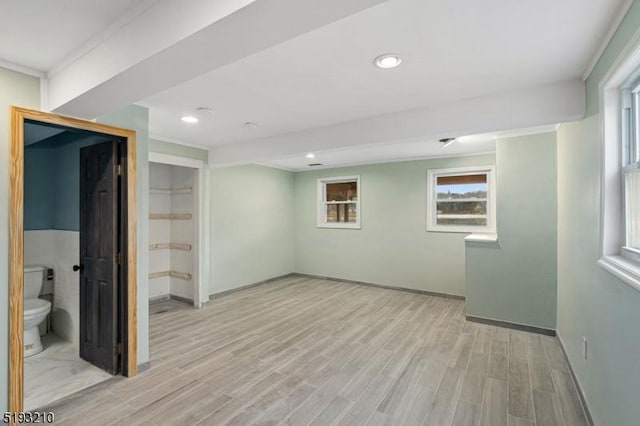 basement with baseboards, recessed lighting, and light wood-style floors