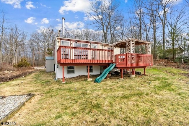 rear view of house featuring a deck and a lawn