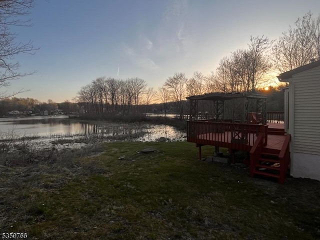 view of yard with a deck with water view