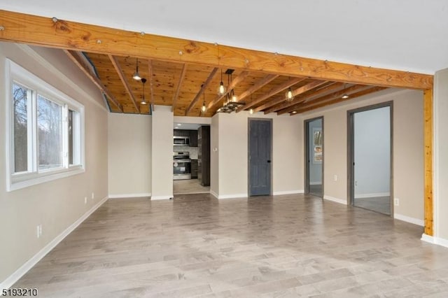 unfurnished living room with beam ceiling, wood finished floors, baseboards, and wooden ceiling